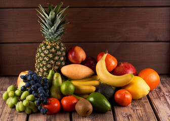 Mix of fresh juicy colorful exotic tropical fruits on wooden background