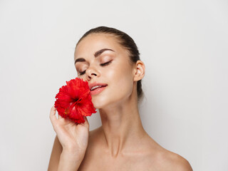 Fototapeta na wymiar pretty woman naked shoulders red flower closed eyes charm