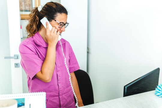 Woman in a doctor's office receives calls from patients - Doctor in a dental clinic makes appointments.