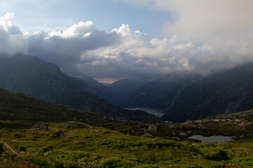 Amazing Landscape in the hearth of Canton Bernese in Switzerland. Drive on the Grimselpass. Epic scenery with the clouds and fog. Wonderful sun rays through the clouds and later an amazing sunset.