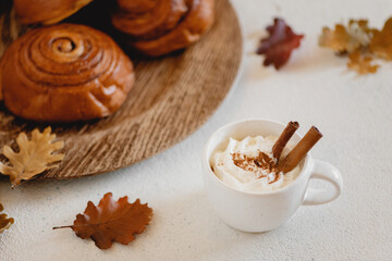 Cocoa with whipped cream and cinnamon rolls. Selective focus.