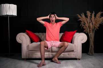 Obraz premium Tired young guy is resting on the couch at home.