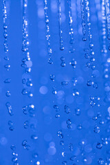Fototapeta na wymiar water drops in the air on blue background