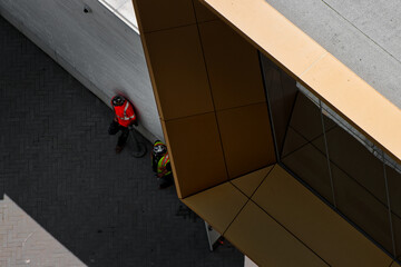 Two construction workers leaning on a wall of a modern building in Toronto, Ontario Canada