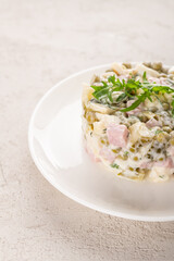 Olivier salad with chicken on a white plate