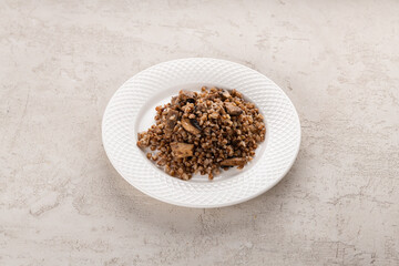 buckwheat porridge with mushrooms on a white plate