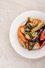 fried vegetables with chicken on a gray background
