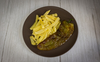 French fries with fried peppers, a very popular food in southern Spain. The potatoes should not be frozen and all homemade. Made all with olive oil. Top view