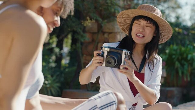 beautiful asian woman taking photo of friends relaxing by swimming pool enjoying sunny day on holiday girls having fun posing for camera making summer vacation memories 4k