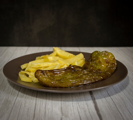Chips with fried peppers, a very popular food in southern Spain. The potatoes should not be frozen, and all homemade. Made all with olive oil