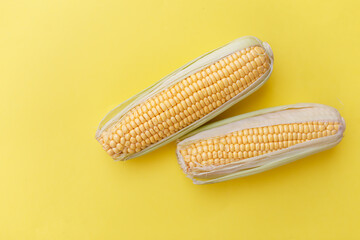 Fresh corn on yellow nackground. Concept on healthy eating.