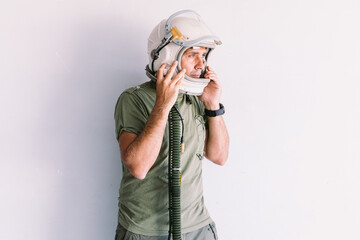 Military man with astronaut cosmonaut helmet, on a white wall