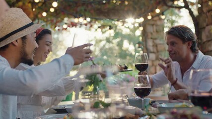 friends celebrating at dinner party eating mediterranean food sharing platter sitting at table enjoying feast at sunset 4k footage