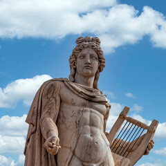 Apollo ancient Greek god statue and blue sky with some white clouds