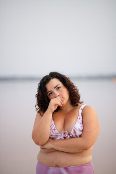 Serene curvy woman in bikini near lake