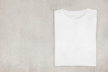White womens folded cotton tshirt mockup on gray concrete background. Design t shirt template,...