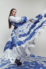 Woman in beautiful long flying dress with blue and white waves