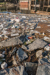 Garbage and trash collects in urban river causing a back up of pollution.
