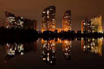 Fototapeta premium night city with reflection of houses in the river
