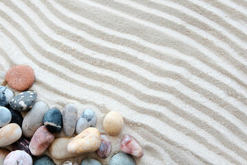 Fototapeta na wymiar Beautiful sea stones, shells on white textured sand. Japanese garden, Zen, relaxation and tranquility in a disturbing world