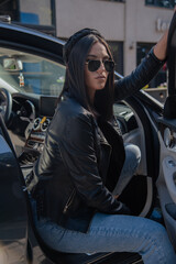Close up image of happy brunette woman in sunglasses and summer clothes posing sideways outdoors