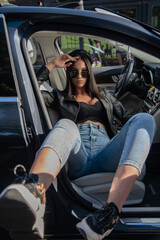 Close up image of happy brunette woman in sunglasses and summer clothes posing sideways outdoors