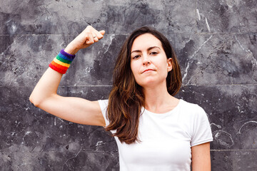 Young lesbian woman showing biceps with rainbow armband. LGBT power