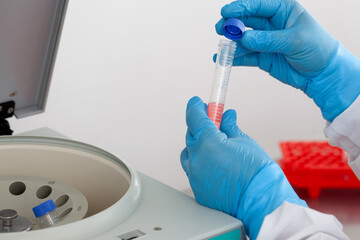 Scientist inserting a tube in a laboratory centrifuge