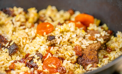 Pilaf with meat, dried apricots and raisins