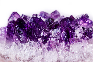 Macro mineral stone purple amethyst in crystals on a white background