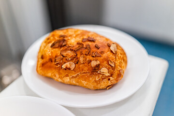 Golden brown baked pastry croissant on plates with flaky crust and almond cream filling as traditional French food and morning breakfast