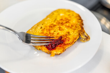 Homemade cooked challah brioche bread french toast fried serving on white plate with fork adding...