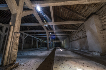 Fototapeta premium inside dark abandoned ruined wooden decaying hangar with rotting columns