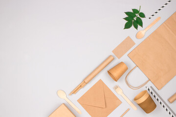 Flat lay composition with eco-friendly tableware - kraft paper food packaging on light gray background with copy space. Street food paper packaging, recyclable paperware, zero waste packaging concept