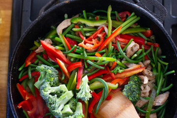 Coocing vegetables in a frying pan. Broccoli, carrots, string beans on cast iron frying pan. Vegetarian Food.