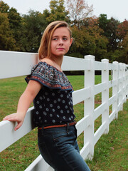 Teen girl leaning against fence