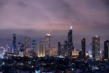 Fototapeta premium A city landscape at night view in Bangkok, metropolitan area of Thailand with the high rise modern building and lighting illumination over the sky 
