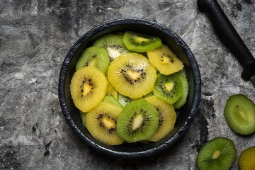 Green and yellow kiwi slices on a plate - 454806121