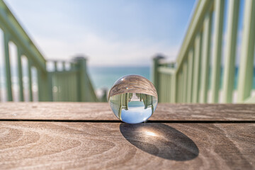 Seaside, Florida with lensball crystal glass ball with reflection of green wooden pavilion steps...