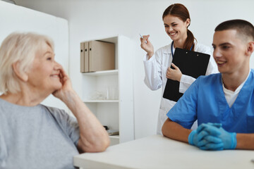 Fototapeta premium elderly woman patient in the hospital at the doctor's and nurse's appointment