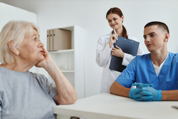 Obraz premium elderly woman patient in hospital talking to medical staff