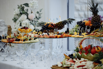 Naklejka na ściany i meble Luxury candy bar on golden wedding. Candy bar decorated by flowers standing of festive table with deserts, and cakes, strawberry tartlet, cupcakes and macarons. Wedding. Reception Tartlets