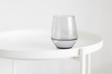 grey glass on a white table, minimalism

