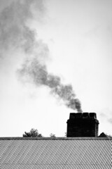 Dark Smoke cloud from chimney smoke stack in black and white. Air polution, carbon emissions, climate emergency, 