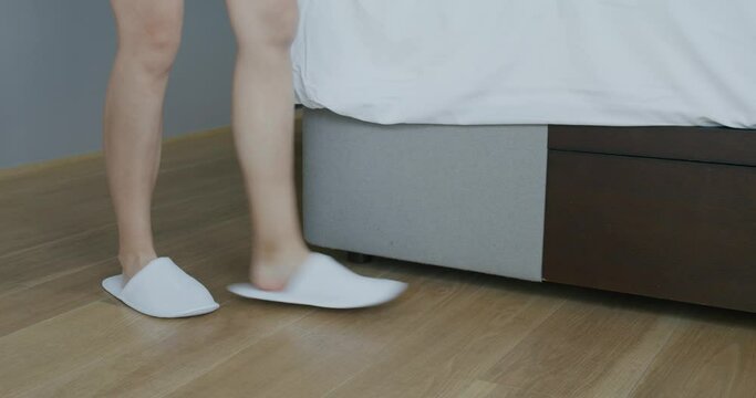 Woman wear white slipper and go on bed