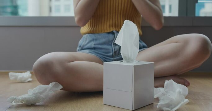 Woman sneeze with tissue at home