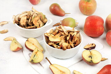 Homemade apple chips in a cup with apples on a white background, in autumn apples are baked in the oven or dryer for storage in winter, delicious healthy diet food,