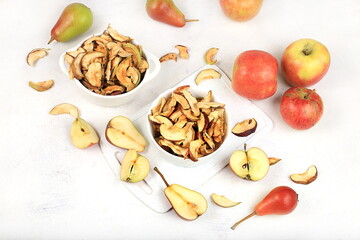 Homemade apple chips in a cup with apples on a white background, in autumn apples are baked in the oven or dryer for storage in winter, delicious healthy diet food, 