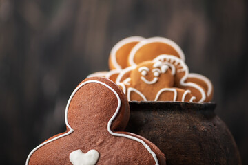 Collection of various gingerbread men in a pot on wooden background