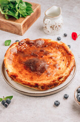 Basque Burnt Cheesecake. Tarta de Queso. The whole cake on light stone background.